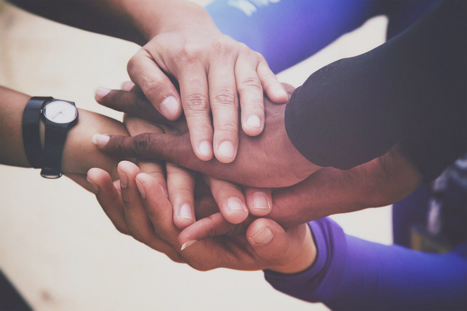 Racially-diverse group of clasped hands